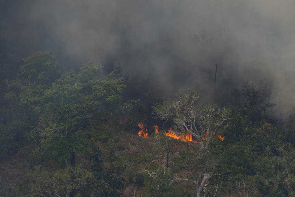 Wildfires consume an area near Porto Velho, Brazil, Friday, Aug. 23, 2019. Brazilian state experts have reported a record of nearly 77,000 wildfires across the country so far this year, up 85% over the same period in 2018. Brazil contains about 60% of the Amazon rainforest, whose degradation could have severe consequences for global climate and rainfall. (AP Photo/Victor R. Caivano)