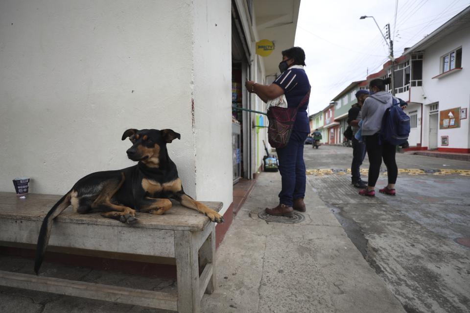 Residents buy groceries at the door of the supermarket after the marketplace was closed due to the new coronavirus pandemic in Campohermoso, Colombia, Thursday, March 18, 2021. According to the Health Ministry, Campohermoso is one of two municipalities in Colombia that has not had a single case of COVID-19 since the pandemic started one year ago. (AP Photo/Fernando Vergara)