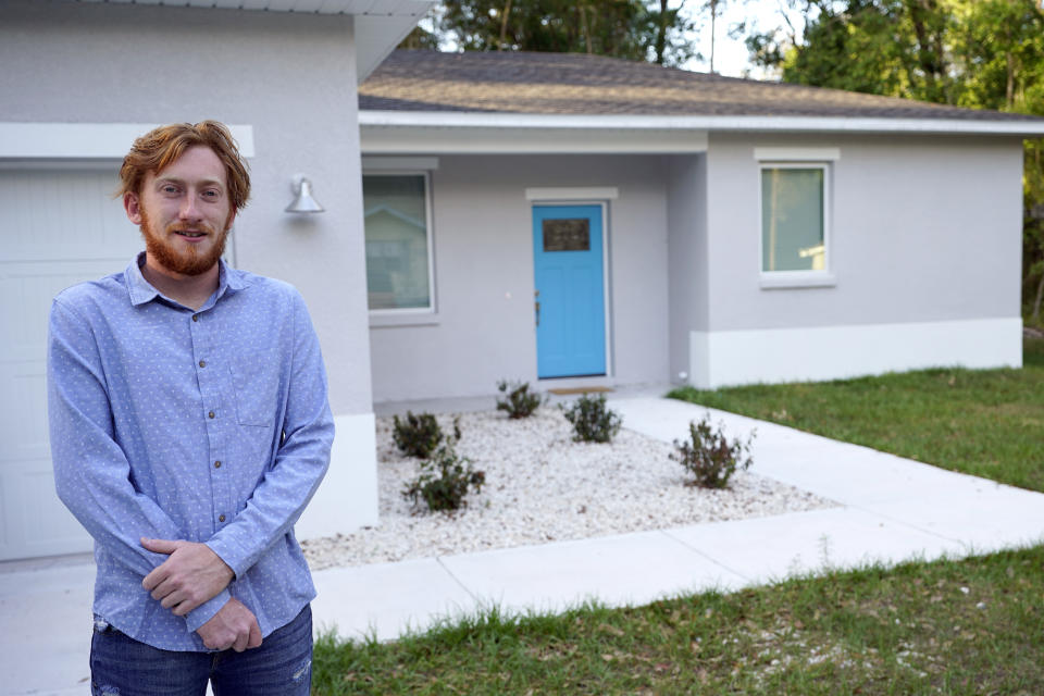 First-time buyer Kevin Muglach stands in front of his new home, Tuesday, April 6, 2021, in Orange City, Fla. Homebuyers are facing the most competitive U.S. housing market in decades this spring, as surging prices and a record-low number of homes for sale narrow the already difficult path to home ownership for many Americans. (AP Photo/John Raoux)