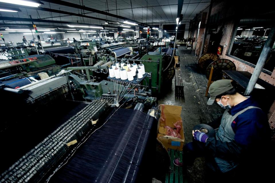 PHOTO: A worker supervises a power loom weaving denim to be used to manufacture blue jeans in LSH textile company, Feb. 9, 2012, in Xintang, Guangdong province, China. (Lucas Schifres/Getty Images)