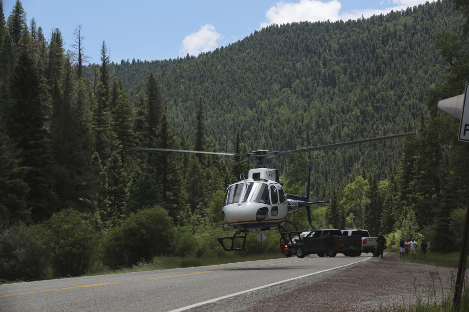 Medical staff lift off carrying an elderly patient from a remote highway on Friday, July 2, 2021, in the Carson National Forest, outside of Taos, N.M. The man fell ill at a remote encampment as part of the annual Rainbow Gathering. More than 2,000 people have made the trek into the mountains of northern New Mexico as part of an annual counterculture gathering of the so-called Rainbow Family. While past congregations on national forest lands elsewhere have drawn as many as 20,000 people, this year’s festival appears to be more reserved. Members (AP Photo/Cedar Attanasio)