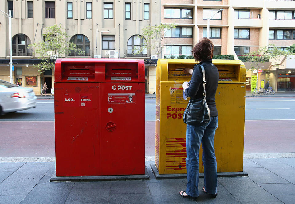 Image of Australia Post boxes with a lady standing in front of it