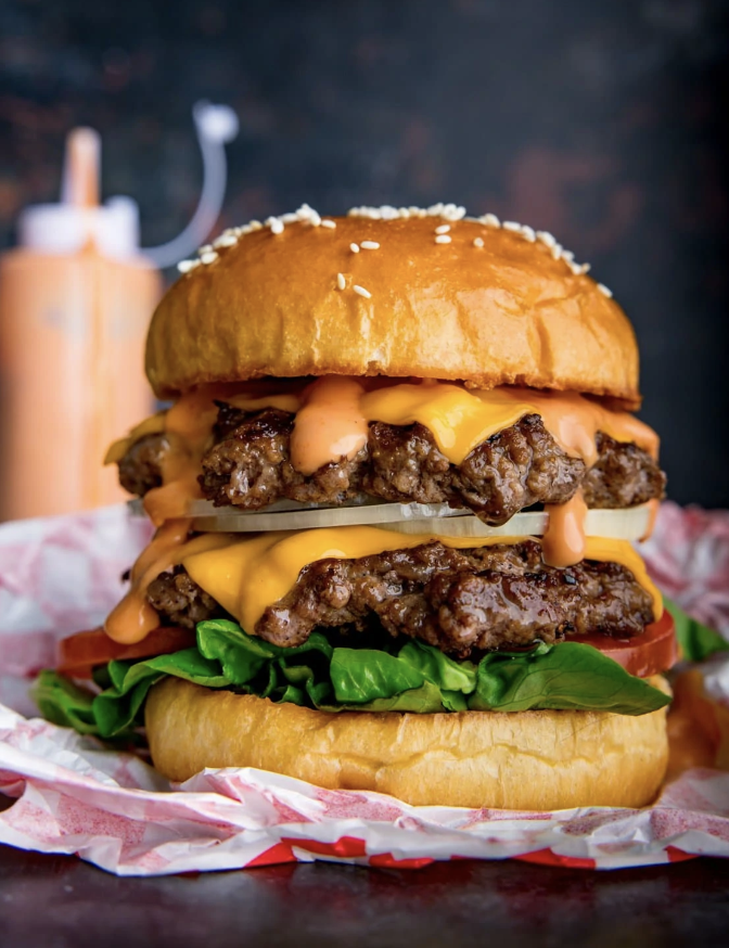 a large cheeseburger on a paper towel