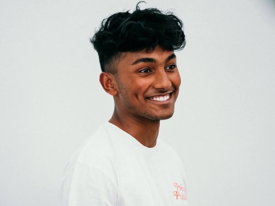 Tejas Hullur, content creator, smiling with all white background