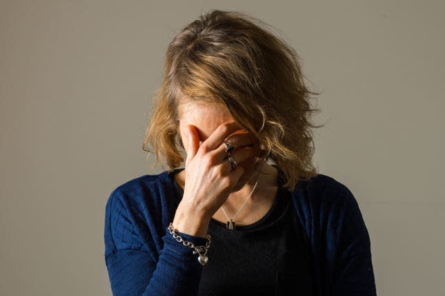 A woman showing signs of depression with her hand over her face.
