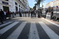 Riot police stand guard during a protest to reject the presidential election in Algiers