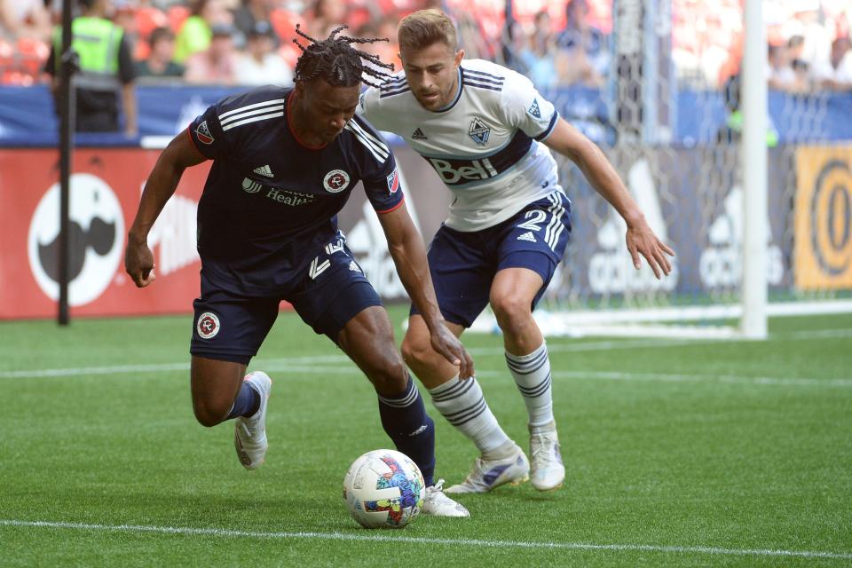 Jun 26, 2022; Vancouver, British Columbia, CAN;  New England Revolution forward DeJuan Jones (24) challenges Vancouver Whitecaps defender Marcus Godinho (2) during the first half at BC Place.