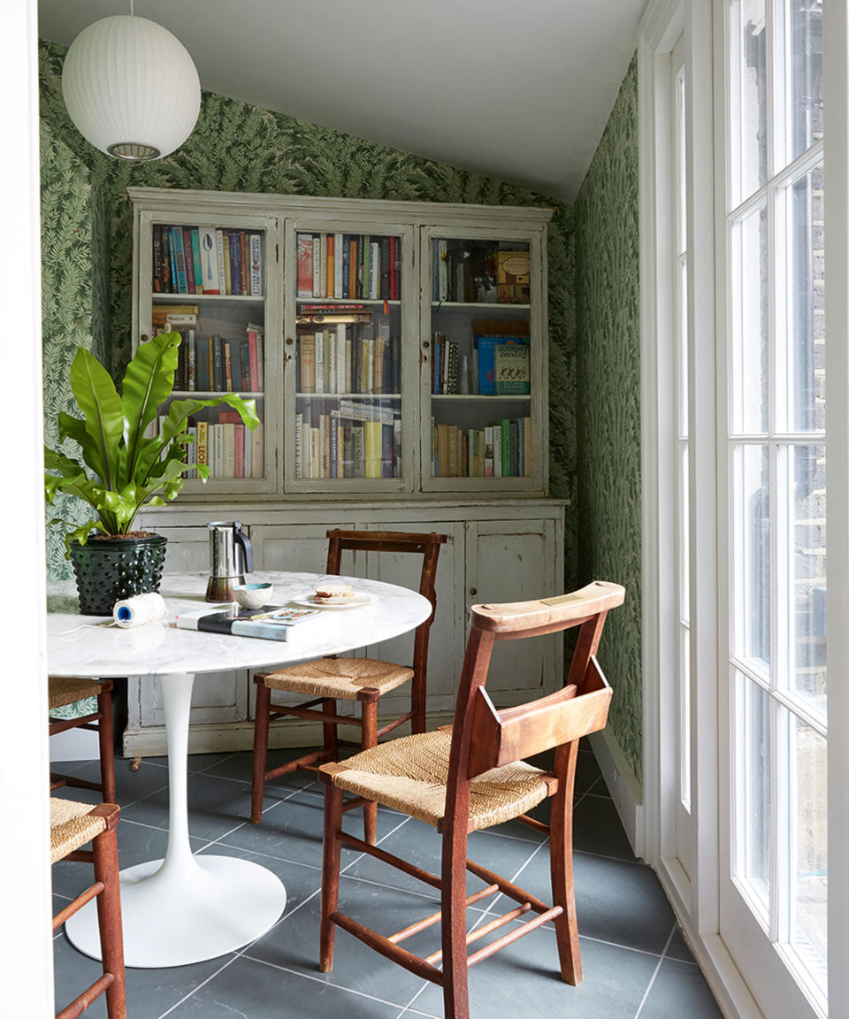 white tulip table with wooden dining chairs and dresser