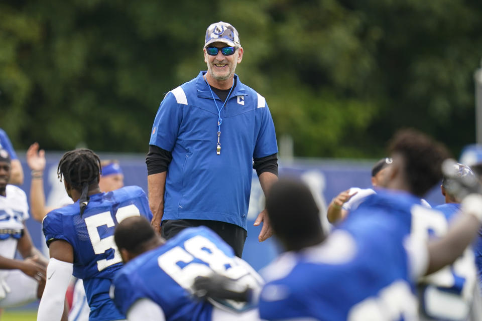 Indianapolis Colts head coach Frank Reich talks with players as they warm up during practice at the NFL team's football training camp in Westfield, Ind., Tuesday, Aug. 2, 2022. (AP Photo/Michael Conroy)