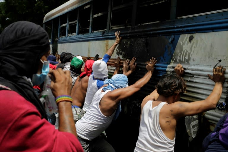 Demonstrators try to turn over a bus set alight during a day-long national strike in Nicaragua
