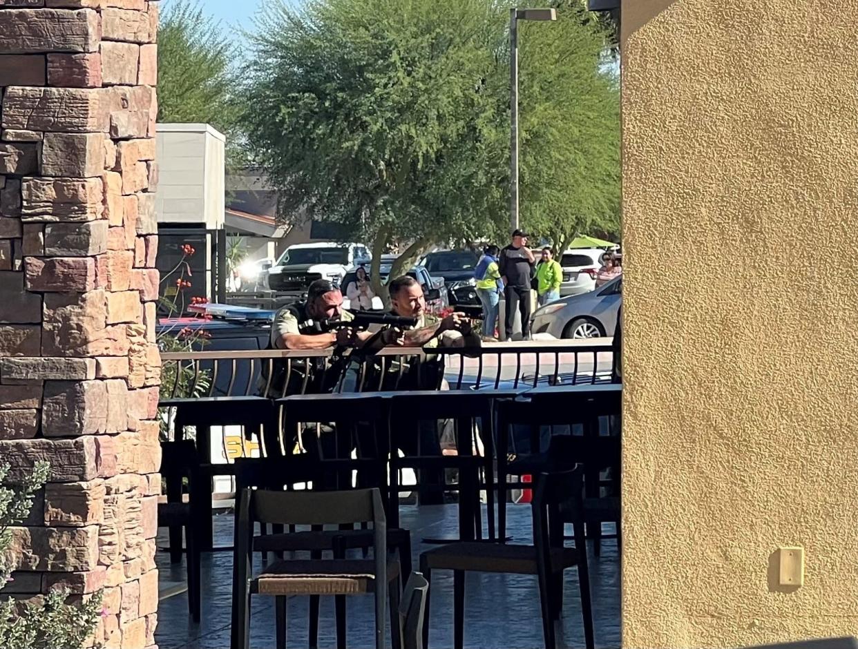 Sheriff's deputies with weapons drawn at a Palm Desert, Calif., shopping center after a man called police making irrational statements, then stabbed himself on Monday, Nov. 20, 2023.