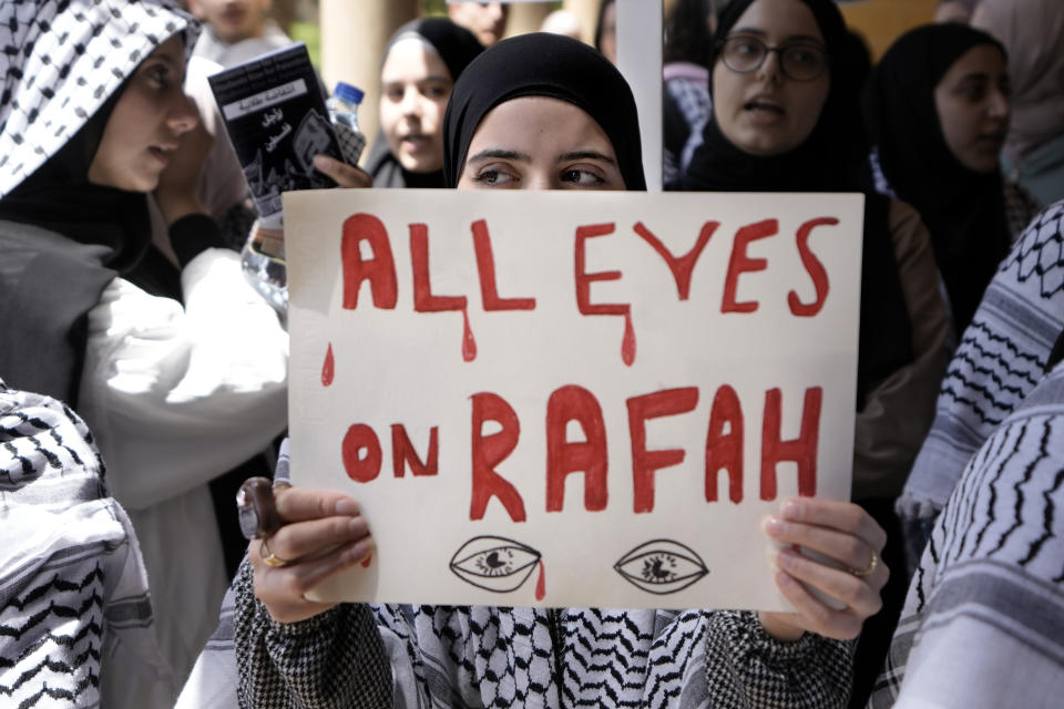 FILE - A student holds a placard as she chants slogans during a protest inside the American University of Beirut to show support for Palestinians in the Gaza Strip, in Beirut, Lebanon, Tuesday, May 7, 2024. A single image, not even an authentic photograph, is the focus of a singular campaign on Instagram that has caught the attention of the algorithm and captured the imaginations of users across national borders — a show of support for the Palestinian movement as the war between Israel and Hamas enters its eighth month. (AP Photo/Bilal Hussein, File)