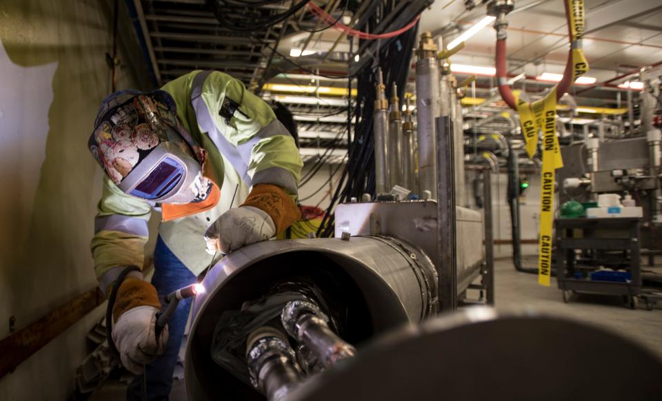 A welder works on specialized equipment inside the Facility for Rare Isotope Beams at Michigan State University on July 25.