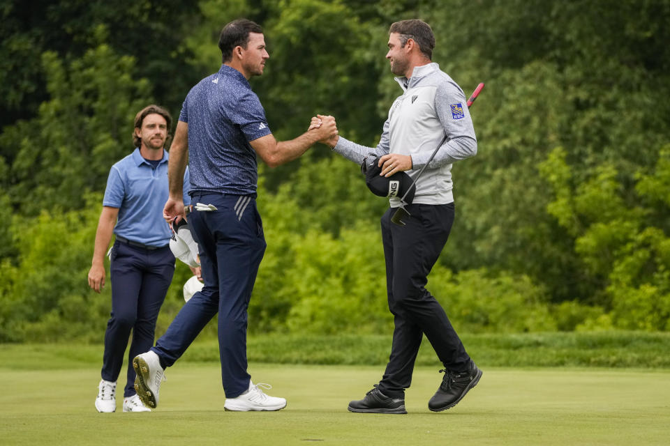 Canadians Nick Taylor, left, and Corey Conners shake hands after finishing the first round of the Canadian Open in Toronto on Thursday, June 8, 2023.(Andrew Lahodynskyj/The Canadian Press via AP)