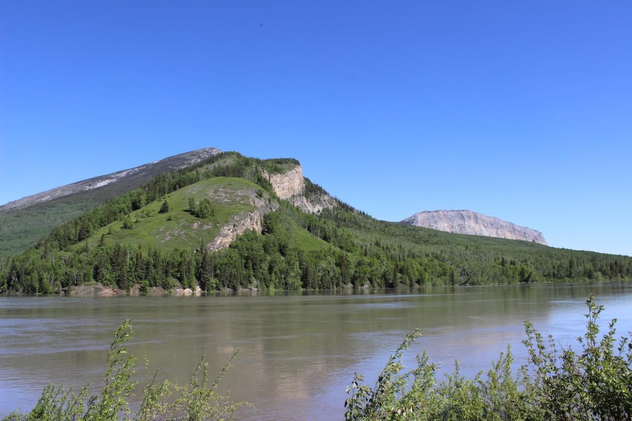 Tthenáágó, the sacred mountain which Nahanni Butte lies at the foot of, in June 2022. Heavy rainfall in the region this week could cause a rapid rise in water levels around Nahanni Butte, the territorial government says.  (Liny Lamberink/CBC - image credit)