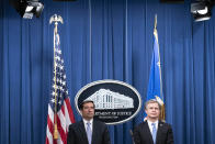 Assistant Attorney General for National Security John Demers, left, and FBI Director Christopher Wray participate in a virtual news conference at the Department of Justice, Wednesday, Oct. 28, 2020 in Washington. The Justice Department has charged eight people with working on behalf of the Chinese government to locate Chinese dissidents and political opponents living in the U.S. and coerce them into returning to China. Five of the eight were arrested Wednesday morning. (Sarah Silbiger/Pool via AP)