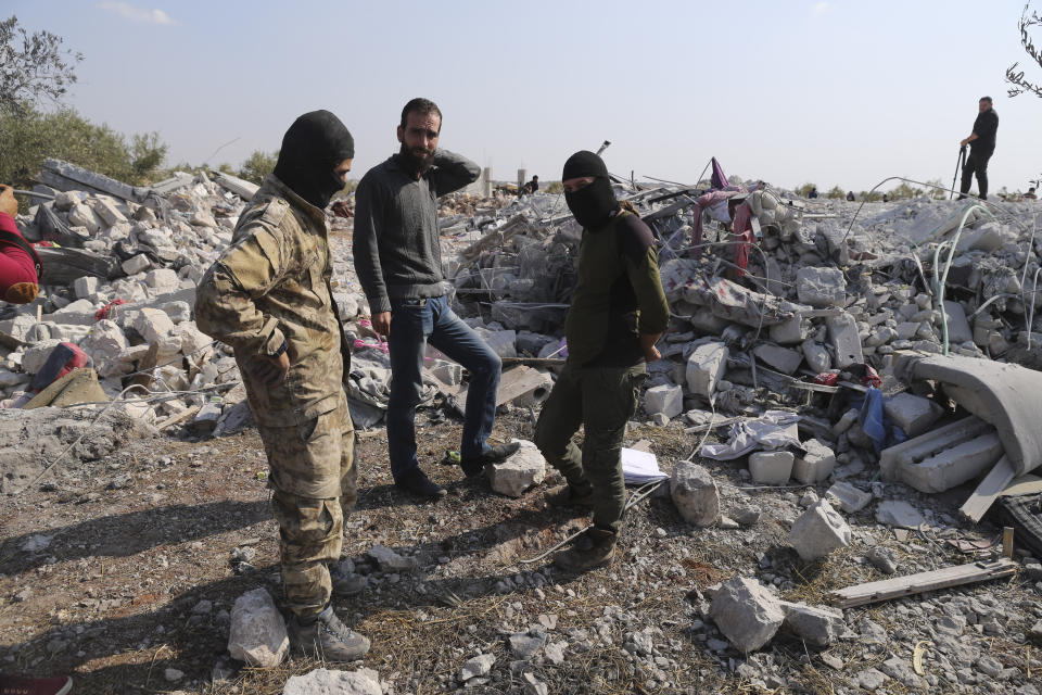 People look at a destroyed houses near the village of Barisha, in Idlib province, Syria, Sunday, Oct. 27, 2019, after an operation by the U.S. military which targeted Abu Bakr al-Baghdadi, the shadowy leader of the Islamic State group. President Donald Trump says Abu Bakr al-Baghdadi is dead after a U.S. military operation in Syria targeted the Islamic State group leader. (AP Photo/Ghaith Alsayed)