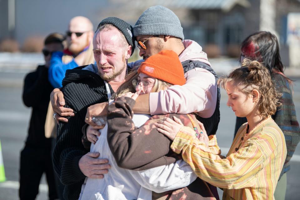 A group of mourners console each other at a makeshift memorial the morning after a mass shooting at Club Q, an LGBTQ nightclub, in Colorado Springs, Colorado.