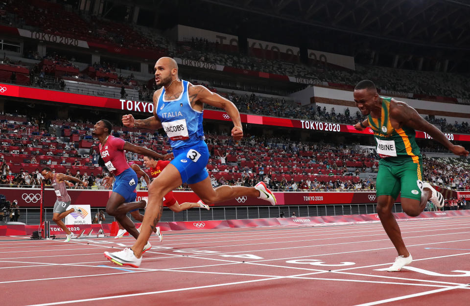 Italy's Marcell Jacobs (in blue) wins the men's 100m final at the Tokyo Olympic Stadium at the 2020 Tokyo Olympics. 