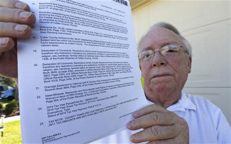 Robert Davidson displays the section of the title to his home which refers to the mineral rights for the home in a Naples, Florida golf course community September 21, 2013. REUTERS/Joe Skipper