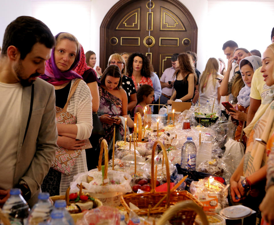 Russian-speaking expats prepare to have their Easter baskets blessed by a priest at the Christian Orthodox Church in Sharjah, United Arab Emirates, Sunday, April 24, 2022. Hundreds of Russians and Ukrainians alike crowded into the only Russian Orthodox Church on the Arabian Peninsula on Sunday to celebrate the most important Christian religious festival of the year — far from home and in the shadow of a war that has brought devastation to Ukraine and international isolation to Moscow. (AP Photo/Isabel Debre)