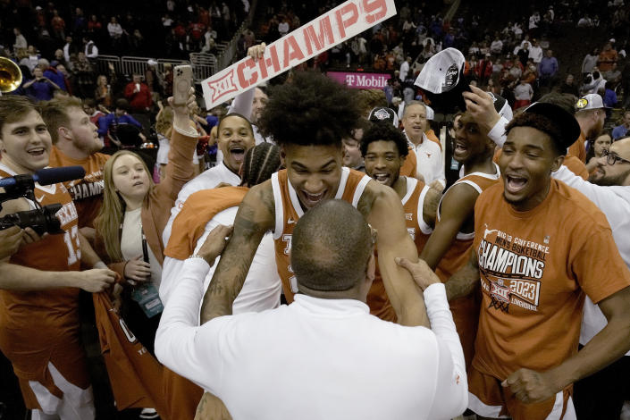 Interim Texas head coach Rodney Terry, bottom, celebrates with Texas forward Dillon Mitchell (23) after Texas won the Big 12 Conference tournament championship NCAA college basketball game against Kansas Saturday, March 11, 2023, in Kansas City, Mo. Texas won 75-56. (AP Photo/Charlie Riedel)