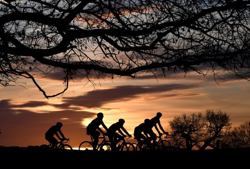 FILE PHOTO: Cyclists ride at sunrise in London