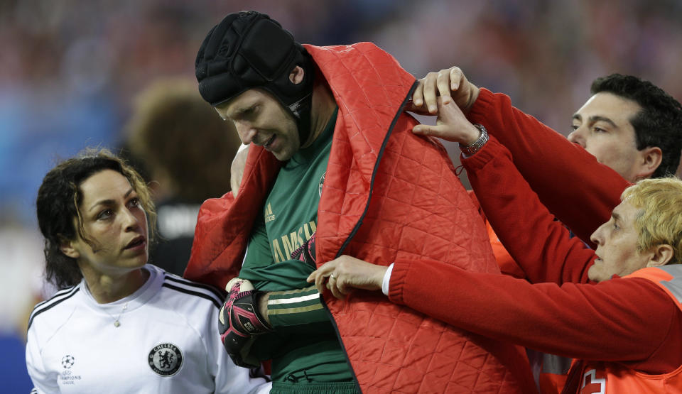Chelsea goalkeeper Petr Cech is covered by a blanket as he leaves the pitch following an injury during the Champions League semifinal first leg soccer match between Atletico Madrid and Chelsea at the Vicente Calderon stadium in Madrid, Spain, Tuesday, April 22, 2014 .(AP Photo/Paul White)