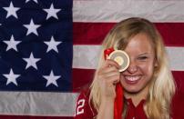 Paralympic swimmer Jessica Long holds up a gold medal as she poses for a portrait during the 2012 U.S. Olympic Team Media Summit in Dallas, May 13, 2012. Long won the gold medal in the Women's 100m Butterfly during the 2008 Beijing Paralympic Games.