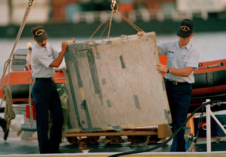 Two U.S. Coast Guard crewmen unload an interior piece from United Airlines Flight 811 in Honolulu, Hawaii.