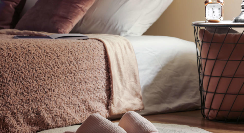 Cozy bedroom setting with women's slippers in foreground