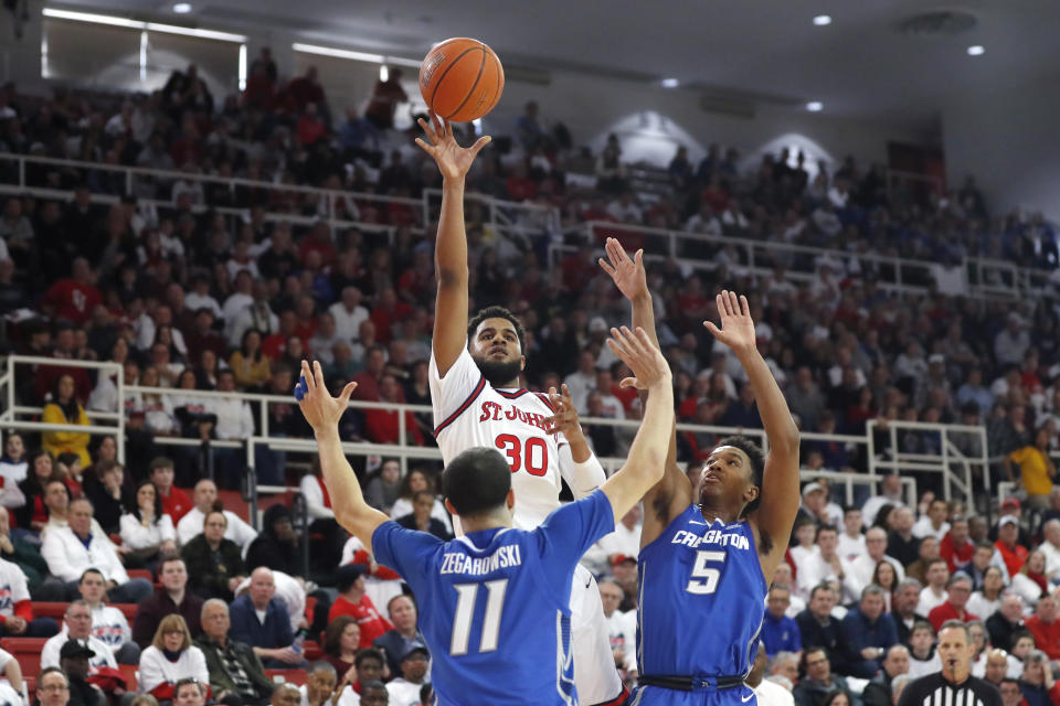 Creighton guard Marcus Zegarowski (11) and guard Ty-Shon Alexander (5) defend as St. John's guard LJ Figueroa (30) shoots a three-pointer during the second half of an NCAA college basketball game, Sunday, March 1, 2020, in New York. St. Johns upset Creighton 91-71. (AP Photo/Kathy Willens)