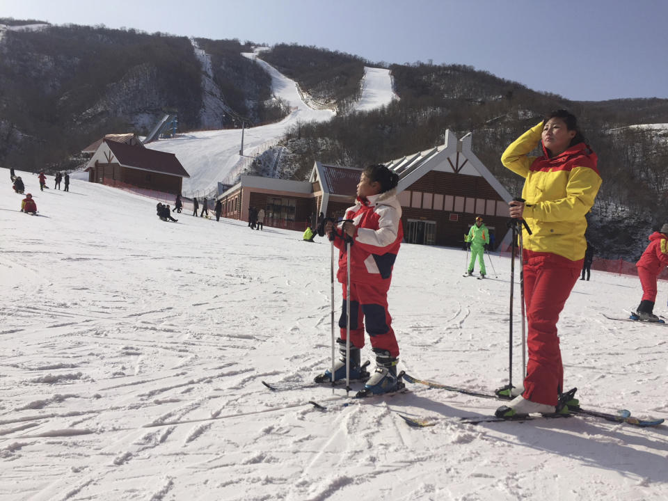 FILE - A mother and her daughter take a rest on the slopes at the Masik Pass ski resort in North Korea on Jan. 28, 2018. Russian tourists going on a ski trip will be the first international travelers to visit North Korea since the country's borders closed in 2020 amid the global pandemic lockdown, according to a report on the Russian state-run Tass news agency. (AP Photo/Eric Talmadge, File)