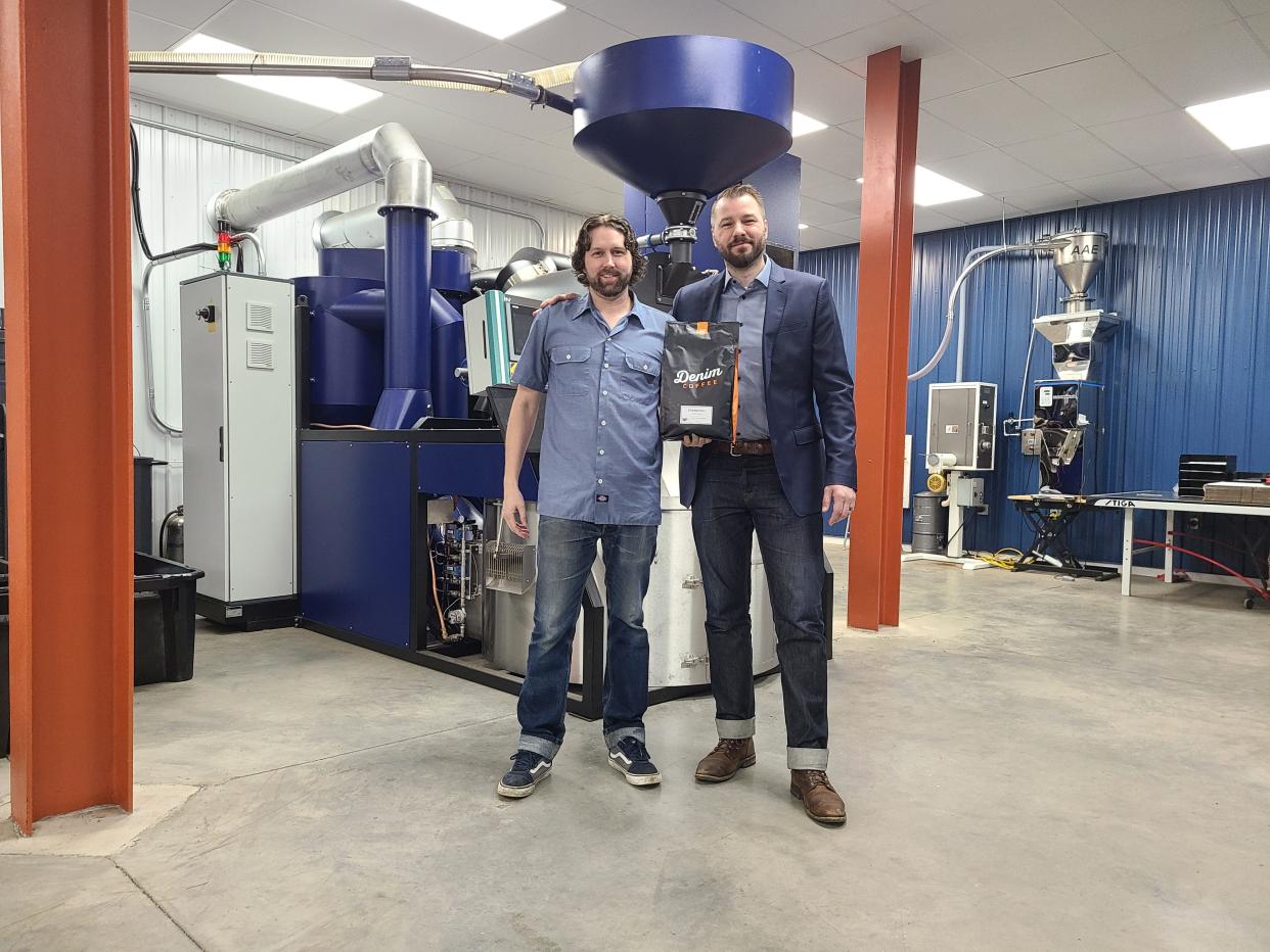 Tony Diehl and Matt Ramsay display a bag of Denim Coffee coffee while standing in front of the company's new state-of-the-art roaster at the company's headquarters in Chambersburg.