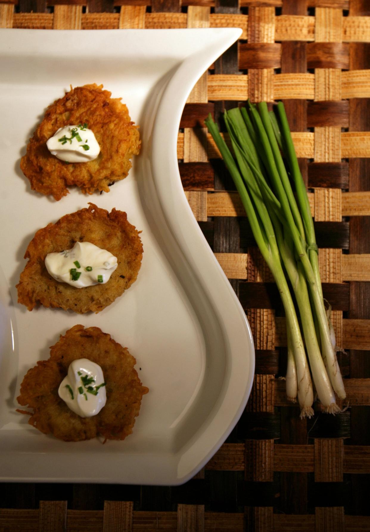 Traditional potato latkes served with a dollop of sour cream.