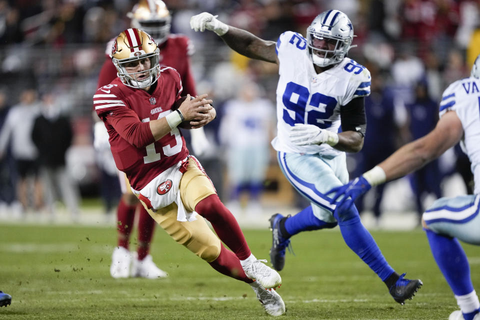 San Francisco 49ers quarterback Brock Purdy (13) runs against Dallas Cowboys defensive end Dorance Armstrong (92) during the second half of an NFL divisional round playoff football game in Santa Clara, Calif., Sunday, Jan. 22, 2023. (AP Photo/Tony Avelar)