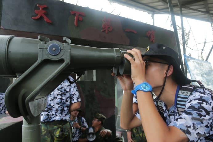 金門戰鬥營學員在天下第一哨透過20倍望遠鏡觀看對岸島嶼，體驗平時官兵駐守外島，觀測敵情的實況。（軍聞社記者葛芃欣攝）