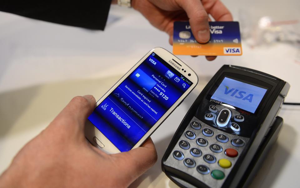 A man uses the NFC payment Visa system at the Mobile World Congress, the world's largest mobile phone trade show, in Barcelona, Spain, Wednesday, Feb. 27, 2013. (AP Photo/Manu Fernandez) ORG XMIT: MF109