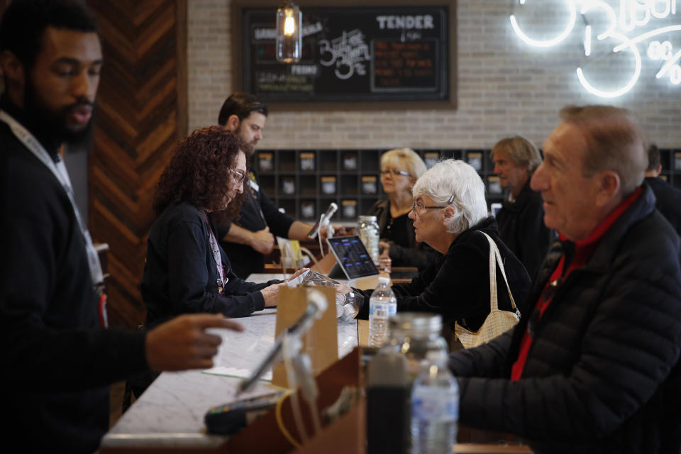 In this Feb. 19, 2019 photo, a group of seniors from Laguna Woods Village consult with sales associates at Bud and Bloom cannabis dispensary in Santa Ana, Calif. The seniors boarded a bus for the pot shop and spent hours choosing from a variety of cannabis-infused products, including candies, drinks and weed. (AP Photo/Jae C. Hong)