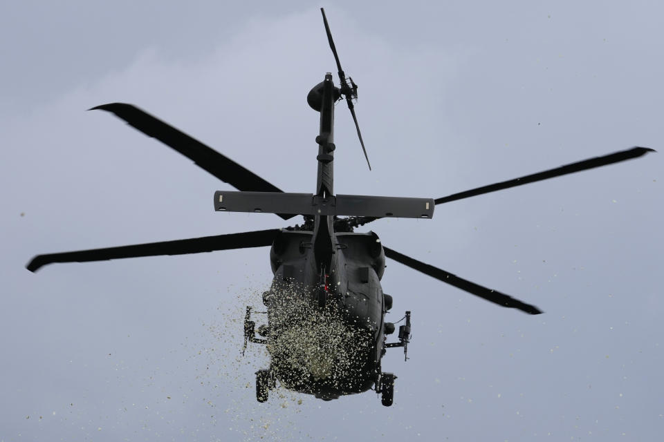 A military helicopter drops petals during the state funeral of the late former Philippine President Fidel Ramos at the Heroes' Cemetery in Taguig, Philippines on Tuesday Aug. 9, 2022. Ramos was laid to rest in a state funeral Tuesday, hailed as an ex-general, who backed then helped oust a dictatorship and became a defender of democracy and can-do reformist in his poverty-wracked Asian country. (AP Photo/Aaron Favila)