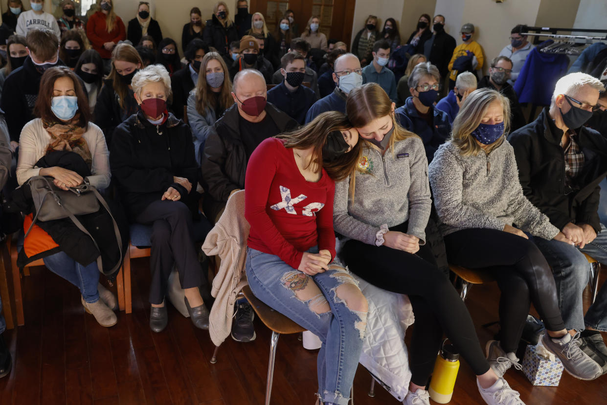 A woman leans on a friend during a prayer vigil at Carroll University in Waukesha, Wis., Monday, Nov. 22, 2021, after an SUV plowed into a Sunday Christmas parade, killing several and injuring dozens of others. (AP Photo/Jeffrey Phelps)