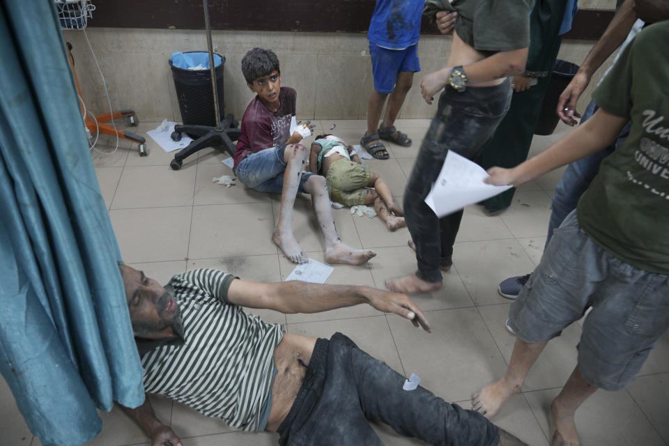 Palestinos heridos por bombardeos israelíes contra la Franja de Gaza sentados en el piso del hospital Al-Aqsa, en Deir Al-Balah, el miércoles 18 de octubre de 2023. (AP Foto/Hatem Moussa)