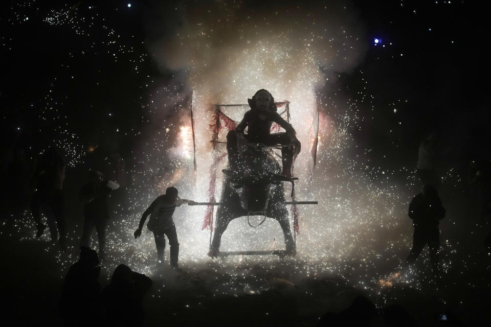 A resident pulls a giant paper-mache "torito" or bull stuffed with fireworks during a nighttime lighting of the bull-shaped figures as part of the annual festival honoring Saint John of God, in Tultepec, Mexico, Friday, March 8, 2024. The celebration, now its 35th year, pays homage to the patron saint of the poor and sick, St. John of God, who the fireworks' producers view as a protective figure. (AP Photo/Marco Ugarte)