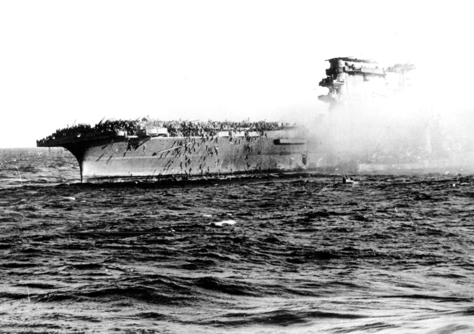 Crews aboard the aircraft carrier USS Lexington abandon ship