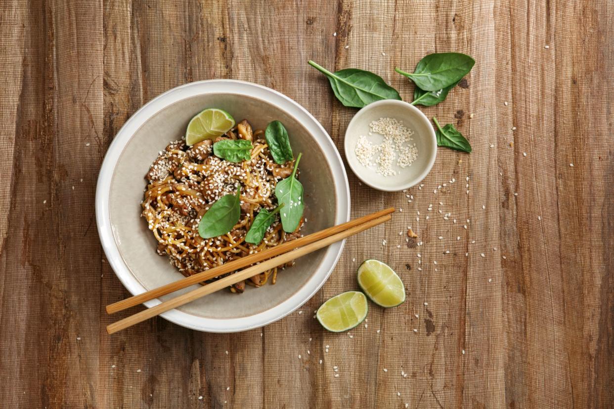 Japanese Beef Stir-Fry with Soba Noodles. Flat lay top-down composition on wooden background. Horizontal image with copy space.