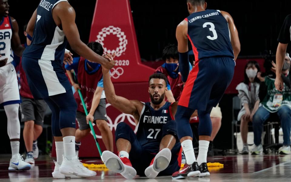 France's Rudy Gobert (27) is helped by his teammates after he was fouled during men's basketball gold medal game against the United States at the 2020 Summer Olympics, Saturday, Aug. 7, 2021, in Saitama, Japan. - AP Photo/Eric Gay