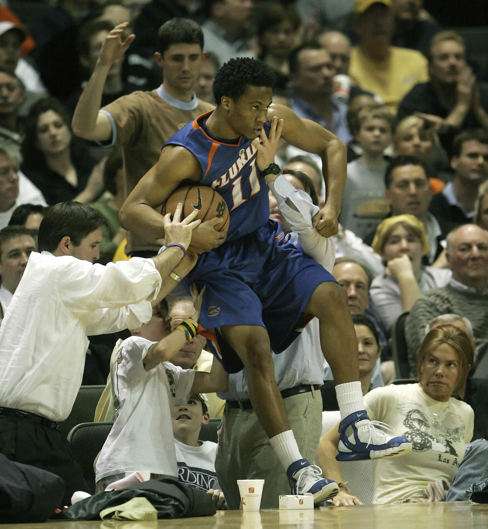 FILE - In this Feb. 15, 2006, file photo, Florida guard Taurean Green gets some help from the fans to keep from falling into the crowd while playing Vanderbilt in the second half of a college basketball game in Nashville, Tenn. Oklahoma State All-American guard Marcus Smart is serving a three-game suspension for shoving a fan who later apologized for his actions. The incident shows how volatile the interaction between fans and athletes is becoming. (AP Photo/Mark Humphrey, File)