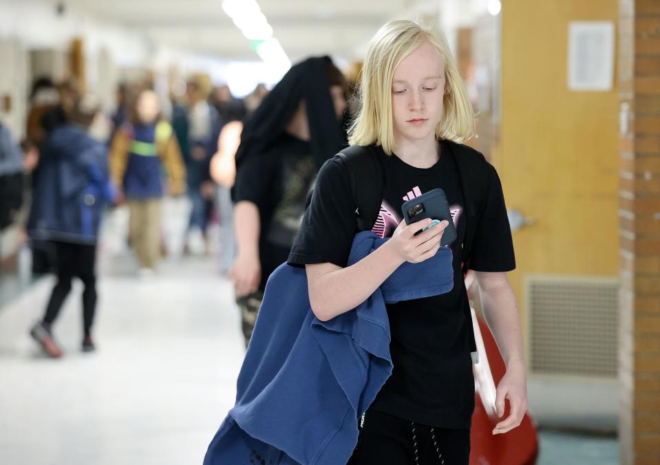 Cruise Palmer uses his cellphone after school at Evergreen Junior High School in Millcreek on Wednesday, Jan. 10, 2024. Phones are banned at Evergreen during the school day but are allowed after the final bell rings. | Kristin Murphy, Deseret News