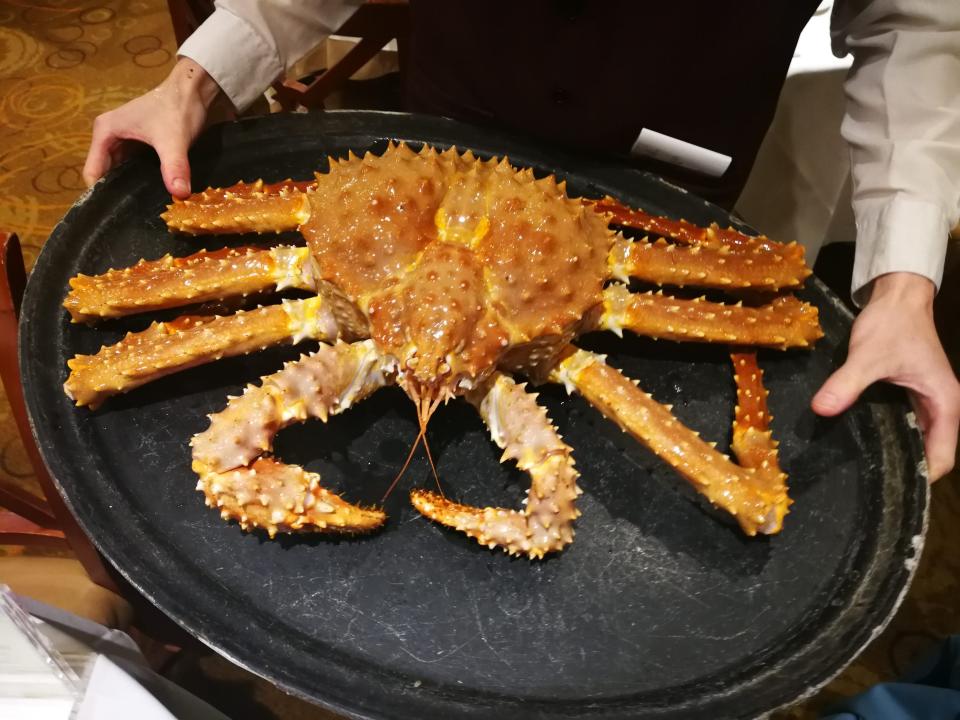 A king crab being served on a tray in a restaurant.