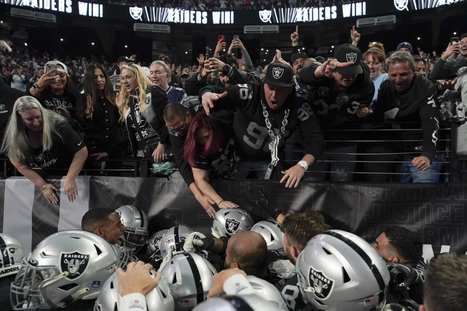 Fans celebrate with players after Las Vegas Raiders defensive end Chandler Jones' touchdown during the second half of an NFL football game between the New England Patriots and Las Vegas Raiders, Sunday, Dec. 18, 2022, in Las Vegas. The Raiders defeated the Patriots 30-24. (AP Photo/John Locher)